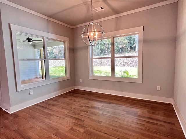 unfurnished dining area with baseboards, visible vents, ornamental molding, dark wood-type flooring, and an inviting chandelier