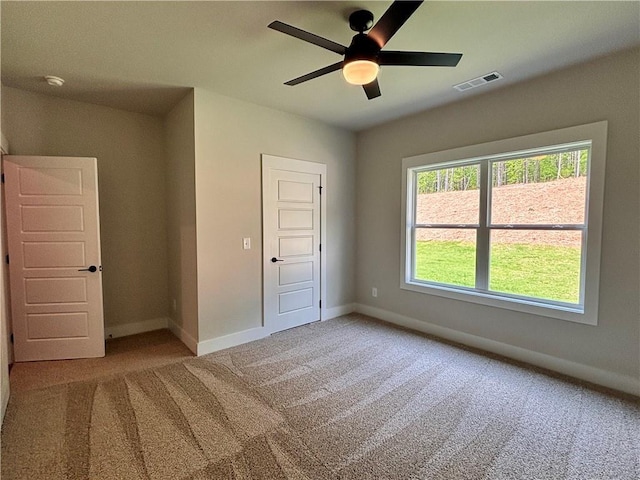 unfurnished bedroom featuring a ceiling fan, carpet, visible vents, and baseboards