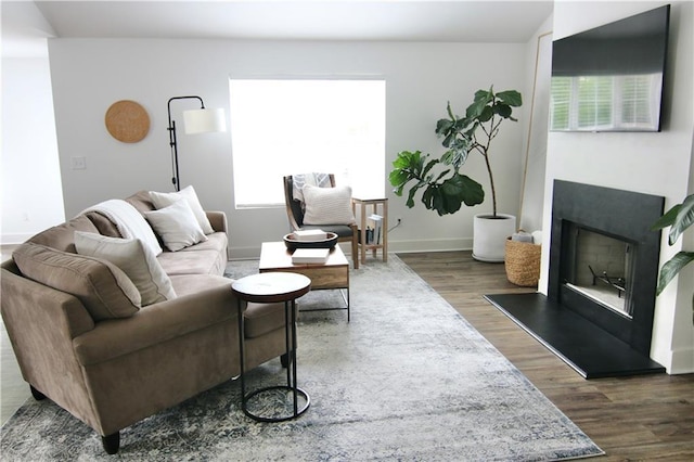 living area featuring dark wood-style floors, lofted ceiling, and baseboards