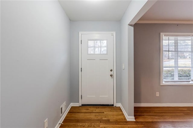 entryway featuring baseboards, wood finished floors, and visible vents