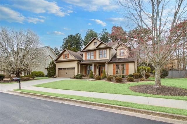 craftsman inspired home featuring a garage, driveway, a front lawn, and fence