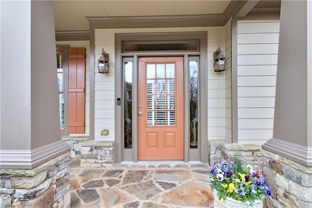 view of exterior entry featuring a porch and stone siding