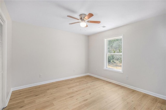 spare room featuring a ceiling fan, baseboards, visible vents, and light wood-type flooring