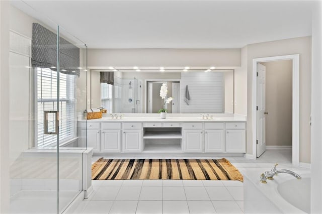 bathroom featuring a stall shower, a sink, a bath, and double vanity