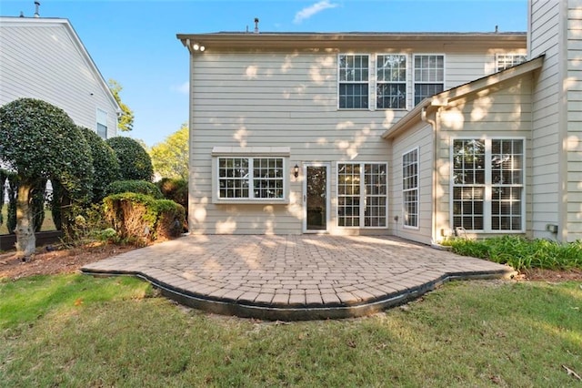 back of house featuring a patio area, a yard, and a chimney