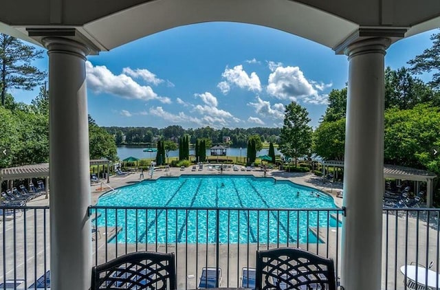 pool featuring a patio area, a water view, and a pergola