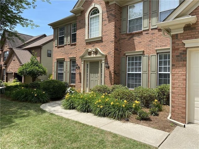 view of front facade featuring a front lawn and brick siding