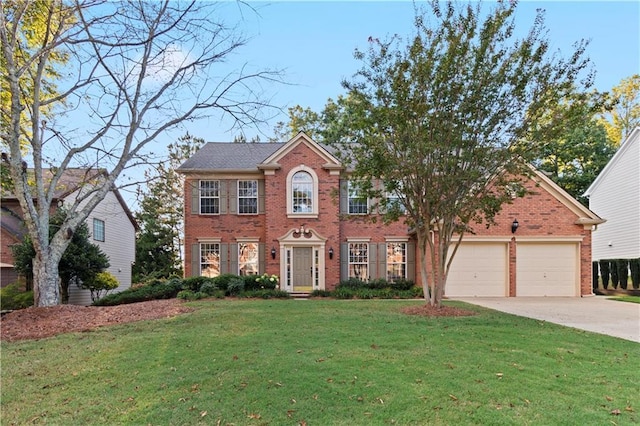 colonial house with a garage, a front lawn, concrete driveway, and brick siding