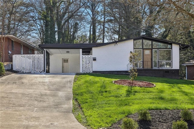 view of front of home with a front yard and a carport