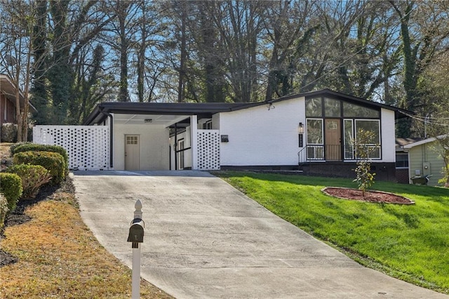 view of front of house with a carport and a front lawn