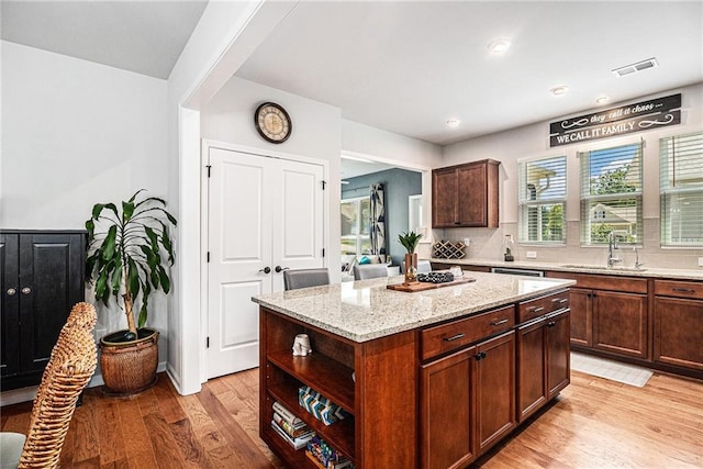 1000 Eight Knot Ct, Greensboro, GA 30642 - kitchen with a sink, light wood-style floors, light stone countertops, a center island, and tasteful backsplash