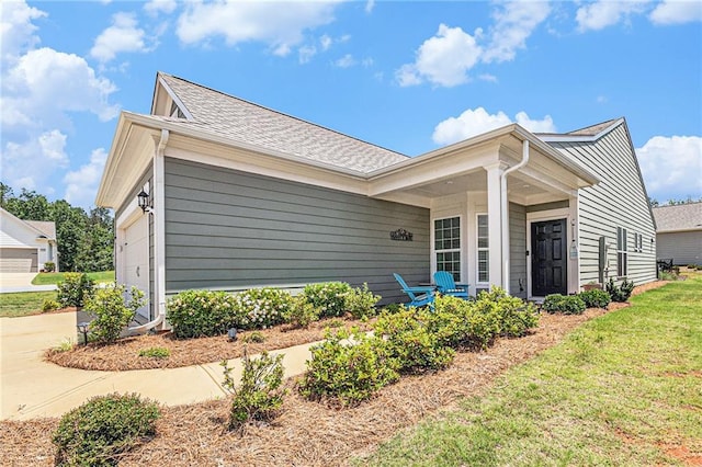 1000 Eight Knot Ct, Greensboro, GA 30642 - view of side of home with covered porch, a shingled roof, a lawn, and driveway