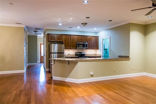 105 Maplecrest Ln, Rome, GA 30161 - kitchen featuring appliances with stainless steel finishes, wood finished floors, light stone counters, tasteful backsplash, and ceiling fan