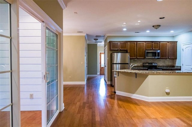 105 Maplecrest Ln, Rome, GA 30161 - kitchen featuring stainless steel appliances, ornamental molding, wood finished floors, backsplash, and stone counters