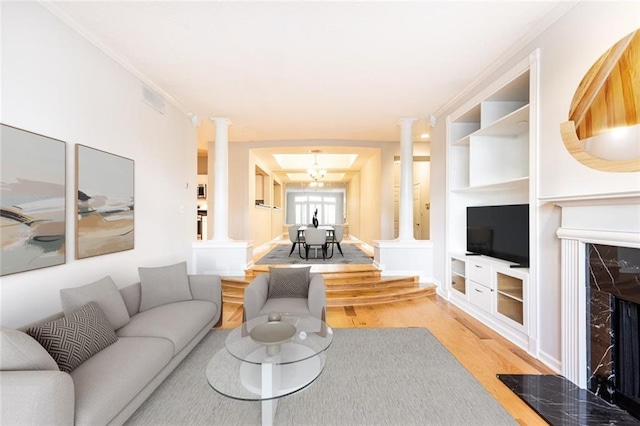 220 Renaissance Pkwy NE Unit 1105, Atlanta, GA 30308 - living room with ornate columns, light wood-style floors, a premium fireplace, and built in features