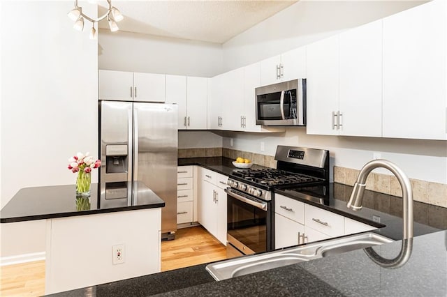 220 Renaissance Pkwy NE Unit 1105, Atlanta, GA 30308 - kitchen featuring stainless steel appliances, light wood-type flooring, white cabinets, and a center island