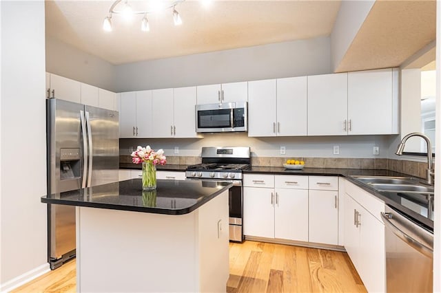 220 Renaissance Pkwy NE Unit 1105, Atlanta, GA 30308 - kitchen with stainless steel appliances, light wood-type flooring, white cabinets, a center island, and dark countertops