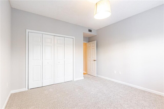 220 Renaissance Pkwy NE Unit 1105, Atlanta, GA 30308 - unfurnished bedroom featuring carpet floors and a closet