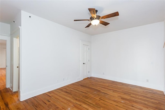 spare room with baseboards, ceiling fan, and light wood-style floors