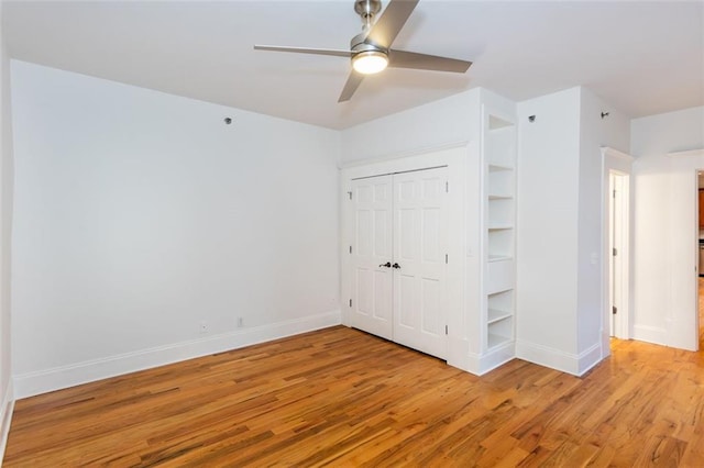 unfurnished bedroom featuring light wood-style flooring, a closet, baseboards, and ceiling fan
