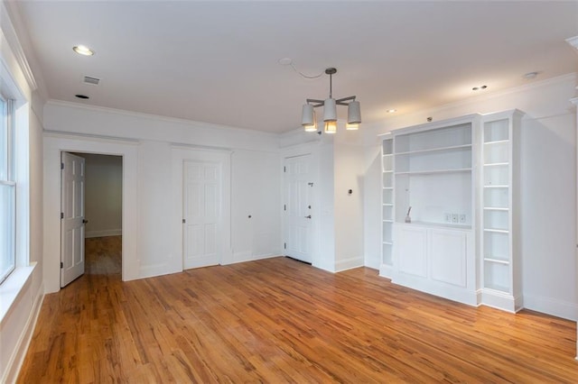 interior space featuring a chandelier, crown molding, baseboards, and light wood finished floors