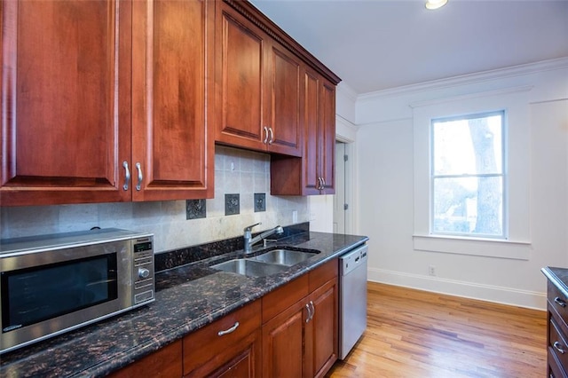 kitchen featuring crown molding, a sink, tasteful backsplash, dishwashing machine, and stainless steel microwave