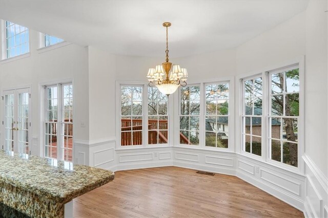 sunroom / solarium featuring a chandelier