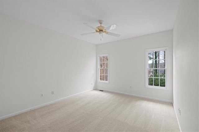 spare room featuring ceiling fan and light colored carpet