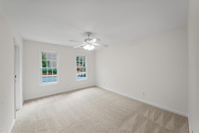 carpeted spare room featuring ceiling fan