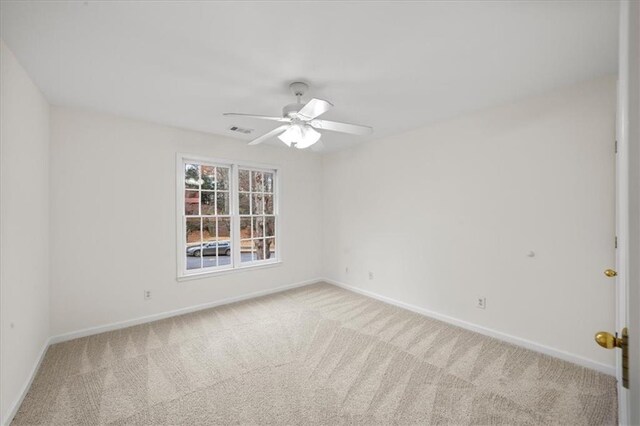 spare room featuring light carpet and ceiling fan