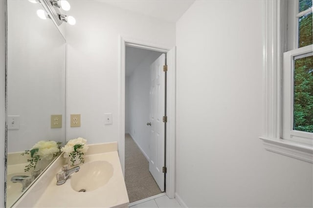 bathroom with tile patterned floors, a healthy amount of sunlight, and vanity