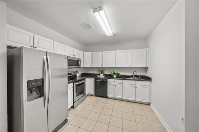 kitchen with light tile patterned floors, stainless steel appliances, sink, and white cabinets