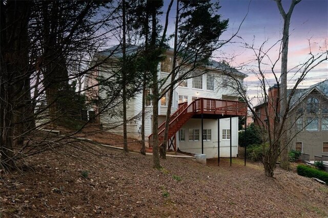 back house at dusk with a wooden deck