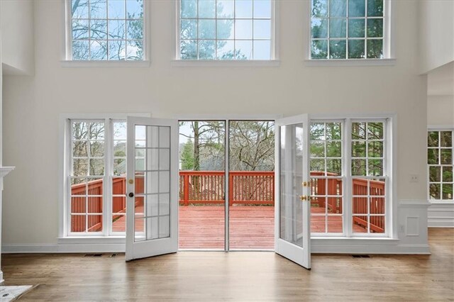 entryway with wood-type flooring, french doors, and a high ceiling