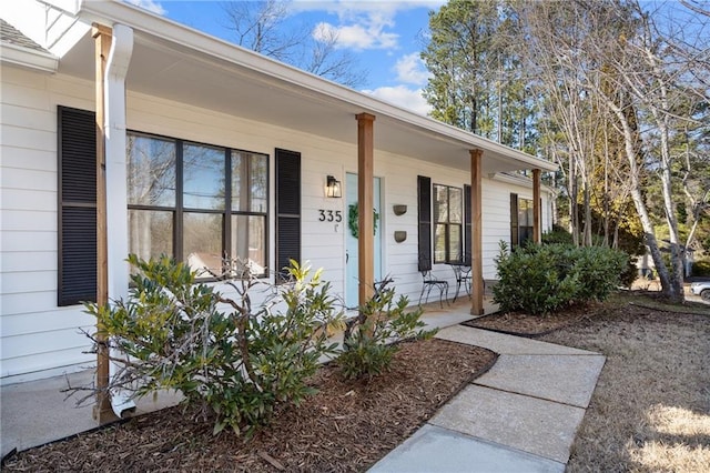 view of exterior entry featuring covered porch