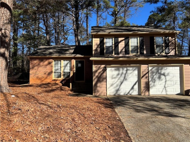 exterior space with driveway, a garage, and brick siding