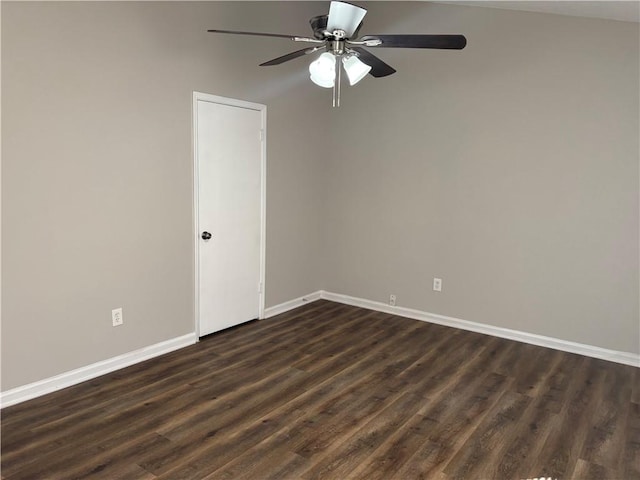 empty room with ceiling fan, dark wood finished floors, and baseboards