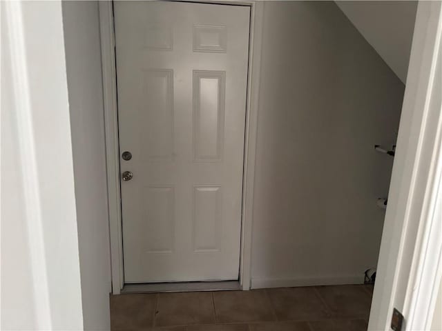 interior space with lofted ceiling and dark tile patterned flooring