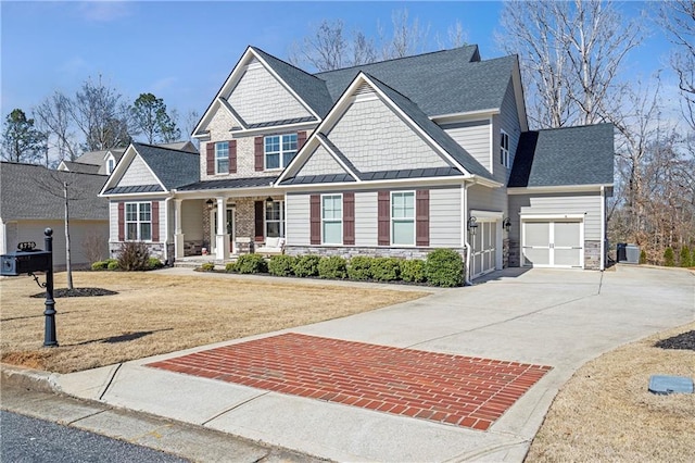 craftsman house with driveway, a standing seam roof, a porch, stone siding, and metal roof