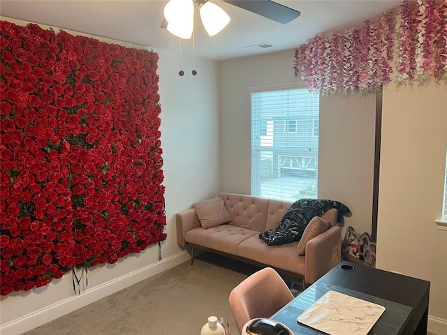 carpeted living area with a ceiling fan and baseboards