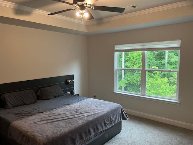 carpeted bedroom featuring baseboards, crown molding, and a ceiling fan