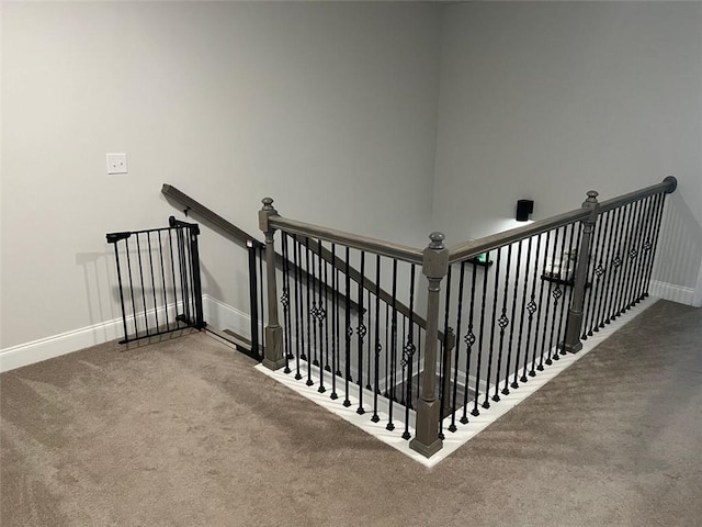 stairway featuring carpet floors and baseboards