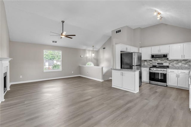 7262 Sandpiper Way, Riverdale, GA 30274 - kitchen featuring appliances with stainless steel finishes, ceiling fan, white cabinets, open floor plan, and high vaulted ceiling