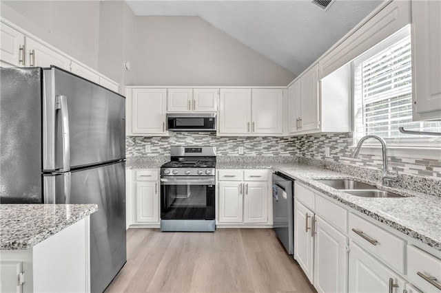 7262 Sandpiper Way, Riverdale, GA 30274 - kitchen with stainless steel appliances, a sink, vaulted ceiling, white cabinets, and backsplash