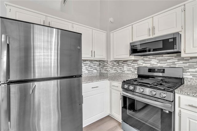7262 Sandpiper Way, Riverdale, GA 30274 - kitchen with stainless steel appliances, backsplash, white cabinetry, and light stone counters
