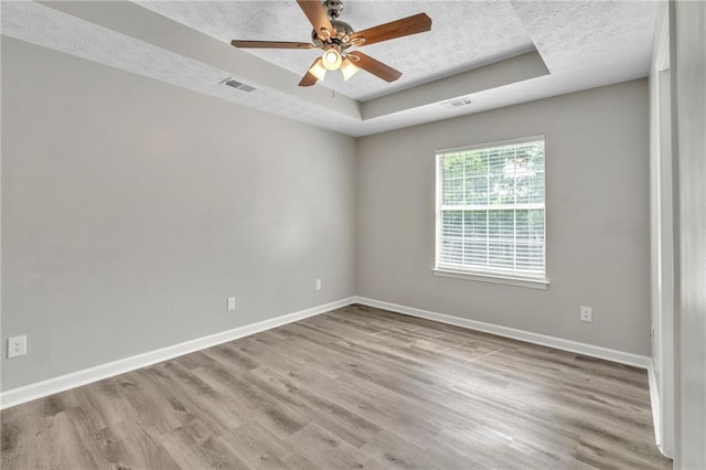 7262 Sandpiper Way, Riverdale, GA 30274 - empty room featuring a raised ceiling, a textured ceiling, baseboards, wood finished floors, and a ceiling fan
