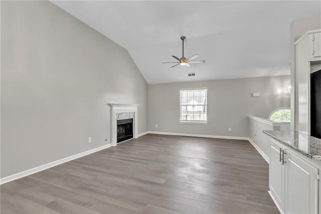 7262 Sandpiper Way, Riverdale, GA 30274 - unfurnished living room featuring a ceiling fan, a fireplace, lofted ceiling, light wood-style floors, and baseboards