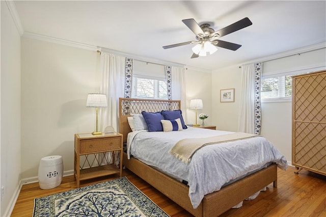 bedroom featuring ornamental molding, ceiling fan, baseboards, and wood finished floors