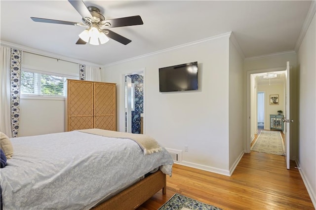 bedroom featuring crown molding, visible vents, attic access, wood finished floors, and baseboards