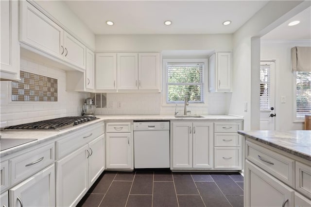 kitchen featuring stainless steel gas cooktop, white cabinetry, white dishwasher, and a sink